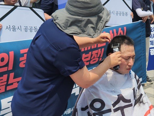 ▲ 오대희 공공운수노조 서울시사회서비스원지부 지부장이 10일 서울시의회 앞에서 열린 기자회견 이후 삭발을 하고 있다.