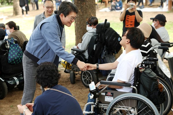 ▲ 정원오 성동구청장(사진 왼쪽)이 장애인의 날 기념행사에서 주민과 반갑게 인사를 나누고 있다.
