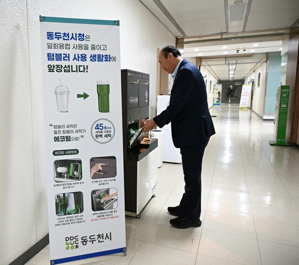 ▲ 박형덕 동두천시장이 텀블러 자동세척기를 사용하고 있다.