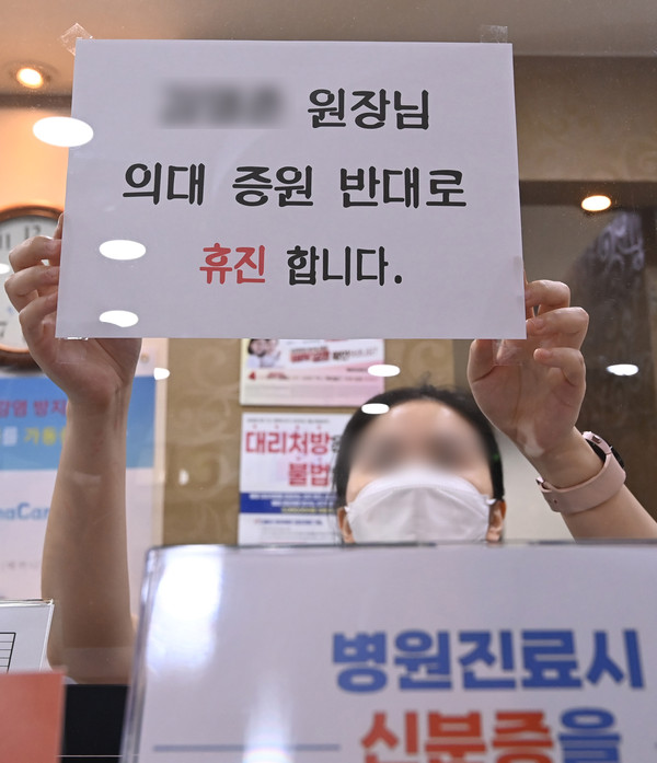 ▲ 17일 경기도 수원시 한 병원에서 관계자가 휴진을 알리는 안내문을 붙이고 있다.