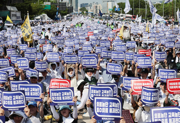 ▲ 대한의사협회가 의대 증원과 관련해 집단 휴진에 돌입한 18일 서울 영등포구 여의도 환승센터 주변에서 열린 대한의사협회 전국 의사 총궐기대회에서 참석자들이 손팻말을 들고 있다. /뉴시스