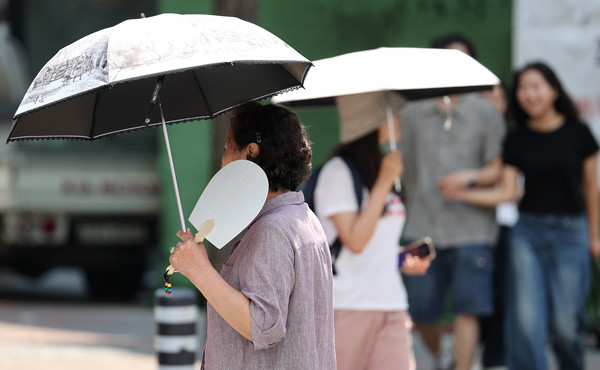 ▲ 전국 곳곳에 폭염주의보가 발효된 지난 19일 대구 중구 동성로에서 한 시민이 부채를 들고 이동하고 있다.