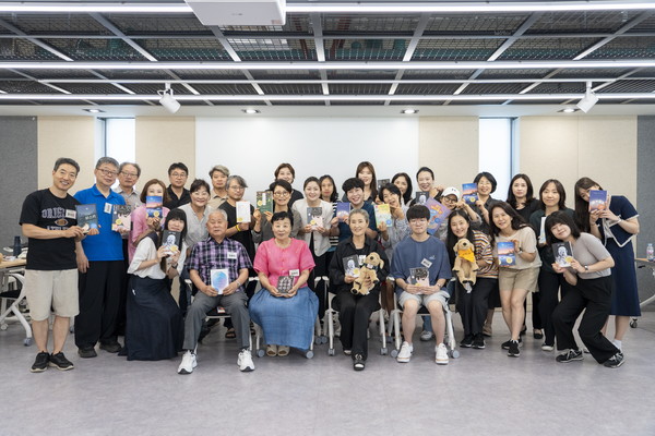 ▲ 다양한 세대가 함께하는 성북구 한책추진단이 선정된 ‘2024 성북구 한 책’ 최종후보도서를 들고 사진을 찍고 있다.