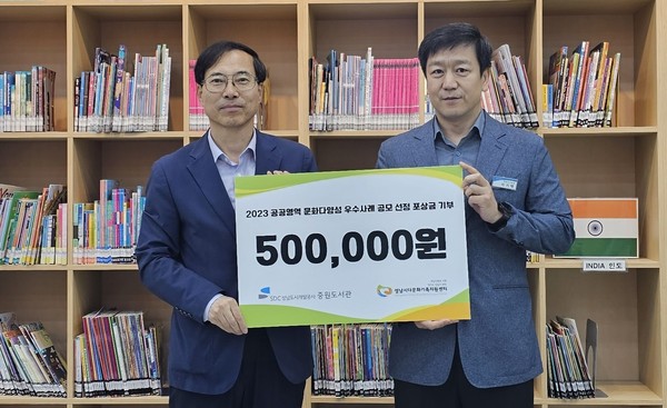 ▲ 중원도서관 이기태 관장(오른쪽)이 성남시다문화가족지원센터에 기부금을 전달하고 기념촬영을 하고 있다.