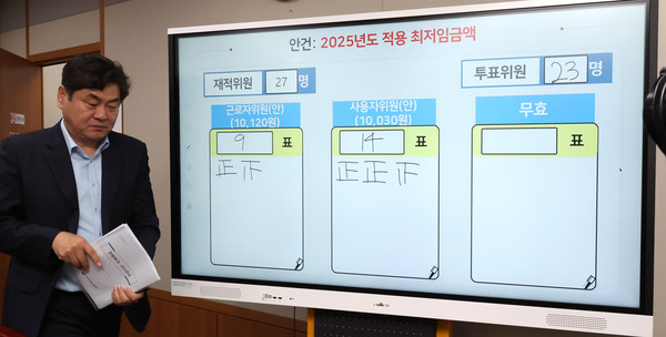 ▲ 이인재 최저임금위원장이 지난 12일 새벽 세종시 정부세종청사에서 2025년도 적용 최저임금에 대한 표결 결과 앞을 지나고 있다.