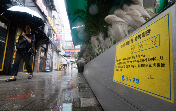 ▲ 장맛비가 내린 지난 8일 서울 동작구 남성사계시장의 한 상점에 물막이판이 구비돼 있다. /뉴시스
