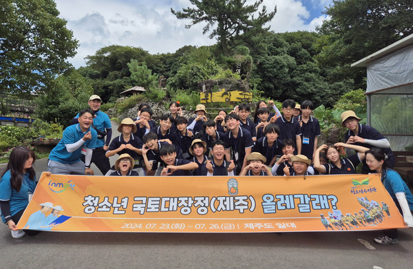 ▲ 과천시 청소년들이 제주 환상숲 앞에서 기념사진을 찍고 있다.