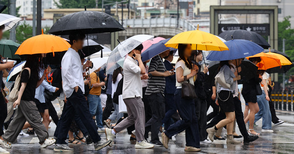 ▲ 장맛비가 내린 지난 2일 오전 서울 용산역 인근에서 우산을 쓴 시민들이 발걸음을 옮기고 있다. /뉴시스