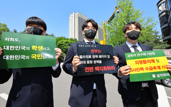 ▲ 지난 4월 22일 오후 서울 서초구 서울중앙지법 앞에서 열린 전국 대학총장 상대 대입전형 시행계획 등 금지 가처분소송 관련 기자회견에서 의대협 학생들이 의대 증원 관련 백지화 촉구 피켓을 들고 있다. /뉴시스