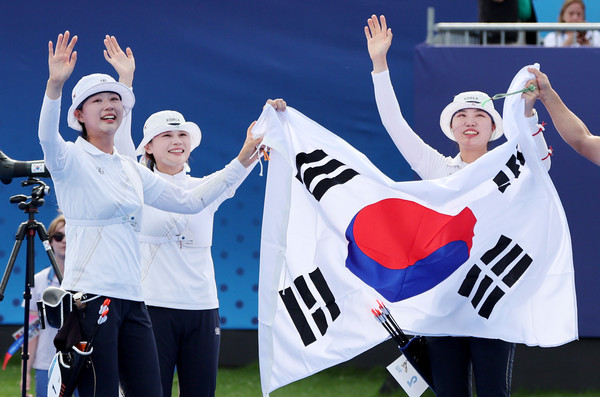 ▲ 임시현, 전훈영, 남수현이 금메달을 확정 지은 뒤 태극기를 들고 기뻐하고 있다. /뉴시스
