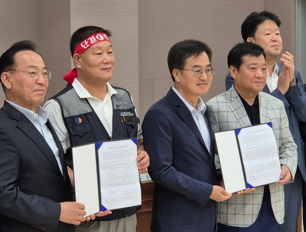 ▲ 김동연 경기도지사와 이기천 경기도버스노동조합협의회 의장, 김기성 경기도버스운송사업조합 이사장 등이 경기지역 버스 파업이 예고됐던 4일 오전 4시께 경기지방노동위원회에서 진행한 조정회의에서 합의점을 찾은 뒤 기념사진을 찍고 있다. /뉴시스