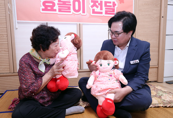 ▲ 지난 5일 박일하 동작구청장이 AI 돌봄로봇 시연에 참관한 가운데 어르신이 '효돌이'를 작동시키고 있다.