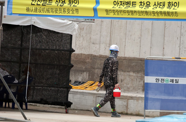 ▲ 지난달 8일 오전 서울 성북구 장위4구역 주택정비사업 건설현장에서 근로자가 음료를 들고 이동하고 있다. /뉴시스