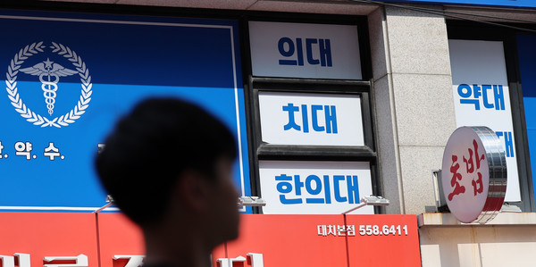 ▲ 지난 8일 서울 강남구 대치동 학원가의 의대 입시 관련 학원 앞을 한 시민이 지나가고 있다. /뉴시스