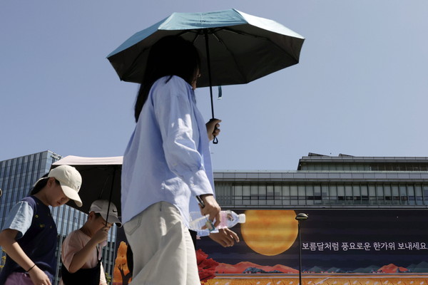 ▲ 추석 연휴 폭염이 이어지고 있는 지난 16일 서울 광화문 광장에서 시민들이 뜨거운 햇살에 양산을 쓰고 걷고 있다.