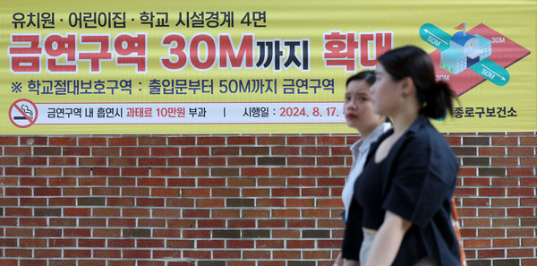 ▲ 지난달 17일부터 어린이집, 유치원, 초·중·고교 경계 30m 안에서 흡연할 경우 10만원 이하의 과태료가 부과된다. 시행을 하루 앞둔 지난달 16일 서울 종로구 한 초등학교 앞에 '금연구역 30M까지 확대' 문구가 적힌 현수막이 걸려있는 모습. /뉴시스