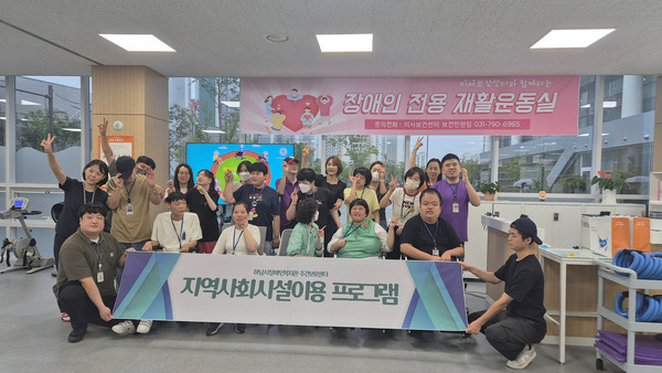 ▲ 하남시장애인복지관 주간보호센터를 이용 중인 장애인들이 '궁금해요 재활운동실' 견학 행사에 참여해 기념촬영을 하고 있다.