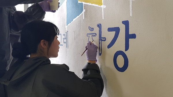 ▲ 벽화 조성하는 봉사활동 참여자 모습.