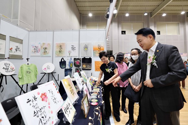 ▲ 김찬진 인천동구청장이 '동구 주민자치 두근두근 페스티벌'에 출품된 작품을 보고 있다.