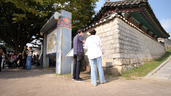 ▲ 시각장애인 김OO씨(왼쪽)가 문화관광해설사와 함께 수원화성을 관광하고 있다.