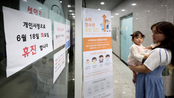 ▲ 대구 시내의 한 소아청소년과를 찾은 엄마와 아이가 휴진 안내문을 바라보고 있다. /뉴시스