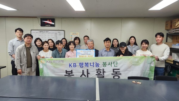 ▲ KB국민은행의 직원 및 가족이 봉사활동 관련 기념촬영을 하고 있다.