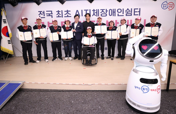 ▲ 박일하 동작구청장이 지난 25일 AI 지체장애인쉼터에서 열린 로봇튜터단 발대식에서 단원들과 함께 기념사진을 촬영하고 있다.