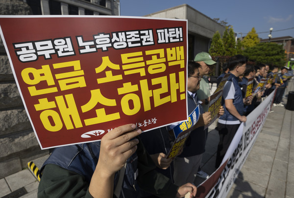 ▲ 전국공무원노동조합 조합원들이 지난 10월 30일 서울 종로구 헌법재판소 앞에서 공무원 노후생존권 연금소득공백 해소를 위한 권리구제 헌법소원청구 기자회견에서 손 피켓을 들고 서 있다. /뉴시스