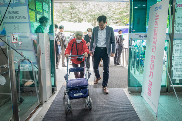 ▲ 보행기를 이용하시는 어르신과 복지관에 입장중인 이기재 양천구청장.