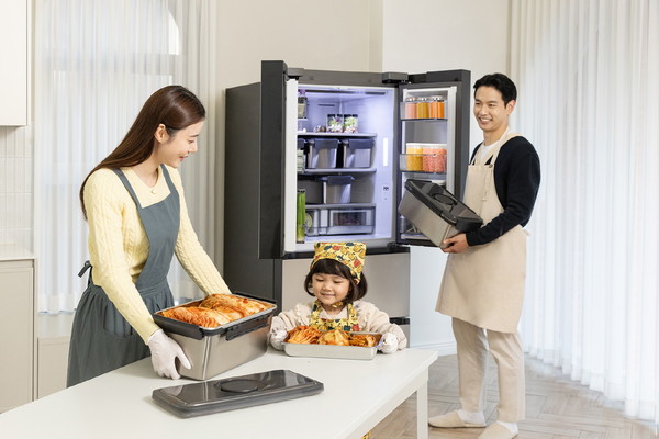 ▲ 삼성전자 모델들이 김치 냄새 퍼짐을 줄여주는 '냄새 케어 김치통'에 김장 김치를 담아 '비스포크 AI 김치플러스'에 보관하고 있다. (사진 = 삼성전자)