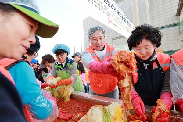 ▲ 이상일 용인특례시장이 김장대첩 행사에서 봉사자들과 김장 김치를 버무리고 있다.