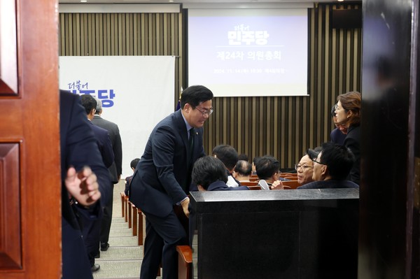 ▲ 박찬대 더불어민주당 원내대표가 14일 오전 서울 여의도 국회에서 열린 비공개 의원총회에서 참석자들과 인사를 하고 있는 가운데 당직자가 문을 닫고 있다. /뉴시스