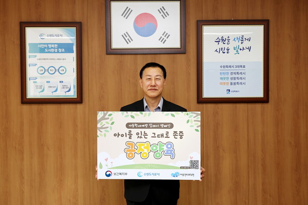 ▲ 허정문 수원도시공사 사장이 18일 오전 더함파크 집무실에서 ‘아이를 있는 그대로 존중 긍정 양육’이 적인 피켓을 들고 아동학대예방 릴레이 캠페인’에 동참하고 있다. (사진=수원도시공사 제공)