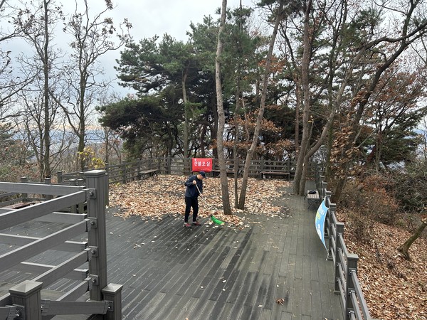 ▲ 지역주민이 설봉산 정상 툇마루 빗질을 하고 있다.