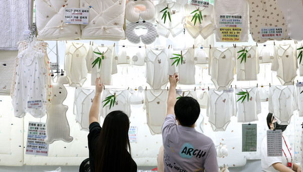 ▲ 지난 8월 16일 대구 북구 엑스코에서 열린 ‘제41회 대구 베이비&키즈페어’를 찾은 관람객들이 배냇저고리를 살펴보고 있다. /뉴시스