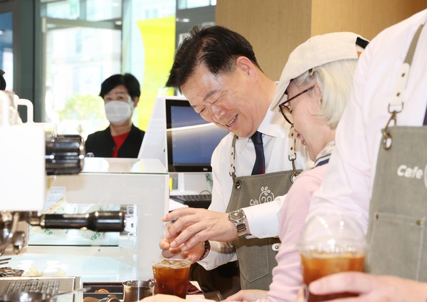 ▲ 지난 4월 개소한 시니어 카페 'CAFE(카페)-20' 개소식에서 박승원 광명시장이 시니어 바리스타와 커피를 만들고 있다.