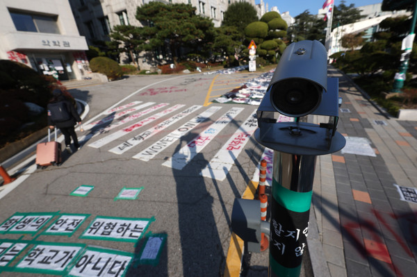 ▲ 지난 11월 24일 오후 서울 성북구 동덕여대에 설치된 CCTV 뒤로 공학 전환 반대 래커칠이 보이고 있다. /뉴시스