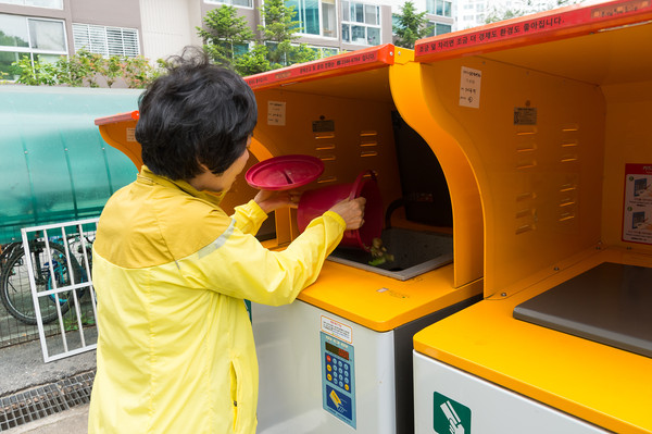 ▲ 음식물폐기물 RFID 종량기에서 음식물을 배출하는 주민 모습.