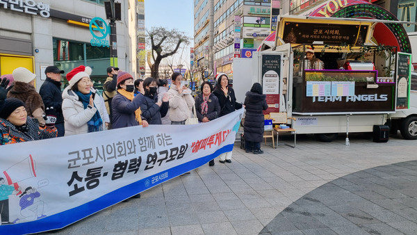 ▲ 군포시의회 의원연구단체 해피투게더는 23일 오후 산본로데오거리에서 시민에게 따뜻한 음료를 제공하는 커피차를 운영하며, 시의원 역할을 소개하는 동시에 시민들이 생각하는 의정활동 중요도를 확인하는 행사를 진행했다.