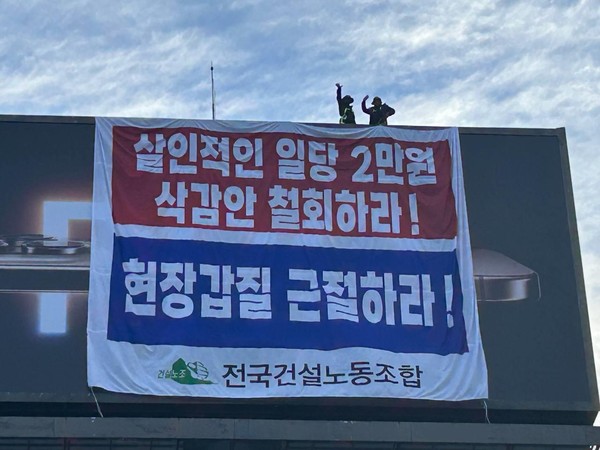 ▲ 임금 협상 체결을 촉구 집회를 앞두고 건설 노동자 2명이 30m 높이의 광고탑에 올라가 농성을 벌이고 있는 중이다. (사진=건설노조 제공) /뉴시스