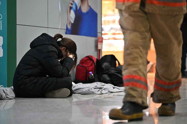 ▲ 제주항공 소속 여객기 착륙 도중 충돌 사고 이튿날인 30일 오전 전남 무안군 무안국제공항 2층 대합실에서 한 유족이 주저앉아 머리를 붙잡고 있다. /뉴시스