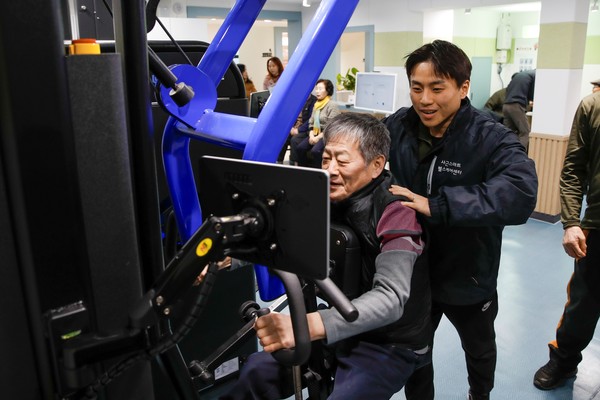 ▲ 건강운동관리사가 어르신에게 근력운동 방법을 지도하고 있는 모습.