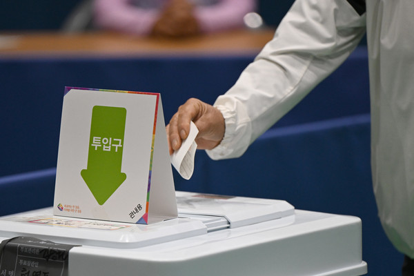 ▲ 10·16 재보궐선거 사전투표 첫날인 11일 오전 전남 곡성군 오곡면 다목적체육관에 마련된 오곡면 사전투표소에서 한 유권자가 투표함에 투표용지를 넣고 있다. /뉴시스