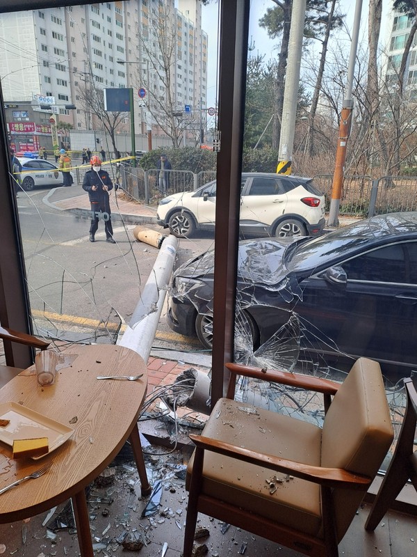 ▲ 25일 오전 10시48분께 전북 군산시 지곡동의 한 아파트 인근의 전신주가 카페로 쓰러져 카페 유리창이 깨져있다. /뉴시스