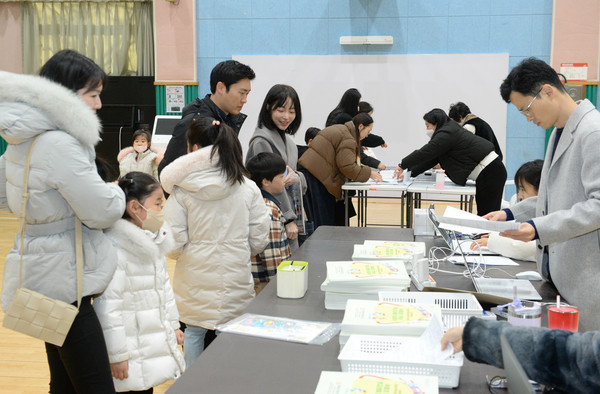 ▲ 2025학년도 초등학교 신입생 예비소집일인 지난 1월 2일 울산 남구 옥동초등학교에서 입학을 앞둔 어린이가 부모와함께 입학 안내자료를 받고 있다. /뉴시스