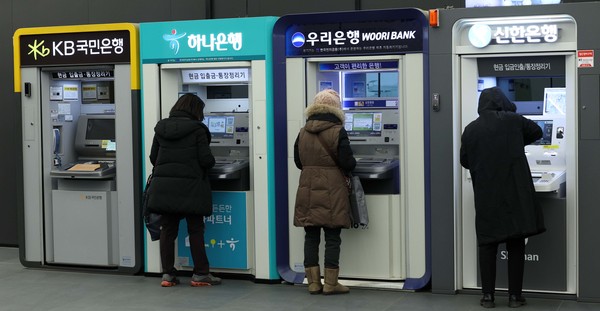 ▲ 서울의 한 건물에 설치된 국민은행 ATM기 앞으로 시민이 지나가고 있다. /뉴시스