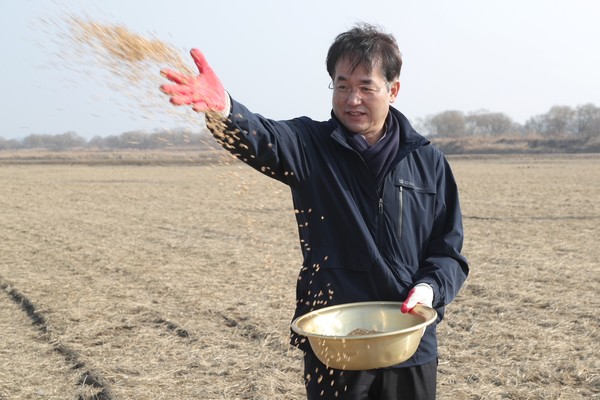 ▲ 철새 먹이주기 행사에서 철새들이 먹을 볍씨를 뿌리고 있는 이동환 고양특례시장.