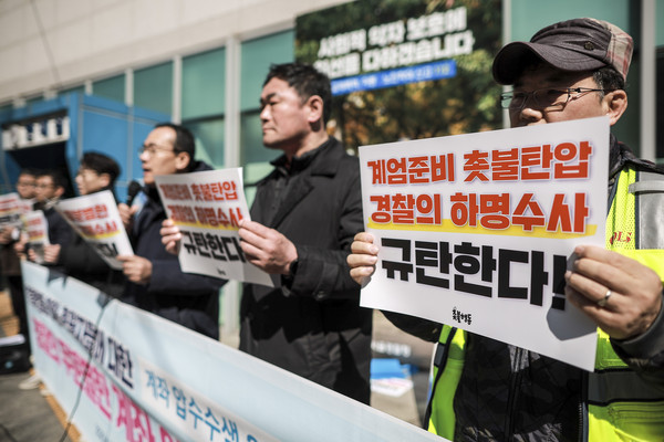 ▲ 19일 서울 종로구 서울경찰청 앞에서 열린 촛불행동 회원, 후원자들에 대한 계좌 압수수색 2차 공동 고소 고발 기자회견에서 촛불행동 회원들이 피켓을 들고 있다. /뉴시스