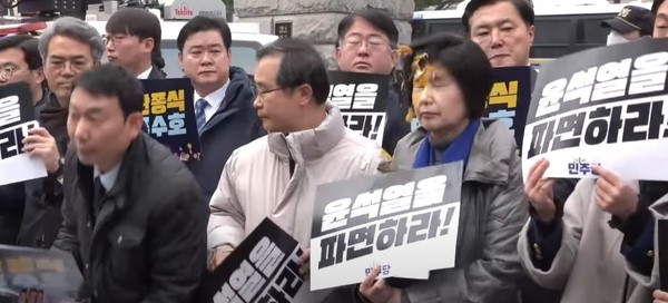 ▲ 백혜련 더불어민주당 의원이 20일 서울 종로구 헌법재판소 정문 앞에서 '윤석열 신속 하면 촉구' 기자회견을 하는 도중 날아온 날계란에 얼굴을 맞는 봉변을 당했다. (사진=민주당 공식 유튜브 채널 델리민주 화면 캡처) /뉴시스