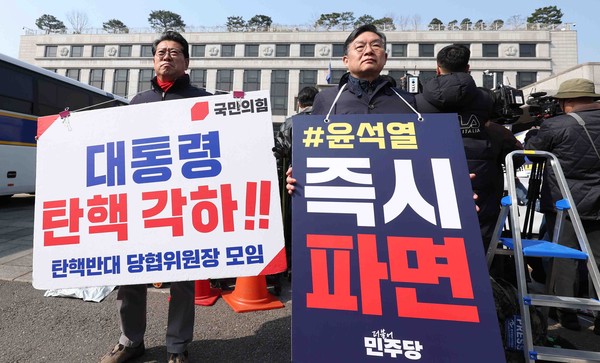 ▲ 21일 오전 서울 종로구 헌법재판소 앞에서 홍윤오 국민의힘 수원시을 당협위원장와 김윤 더불어민주당 의원이 각각 윤석열 대통령 탄핵 각하와 즉시 파면 촉구 1인시위를 하고 있다. /뉴시스